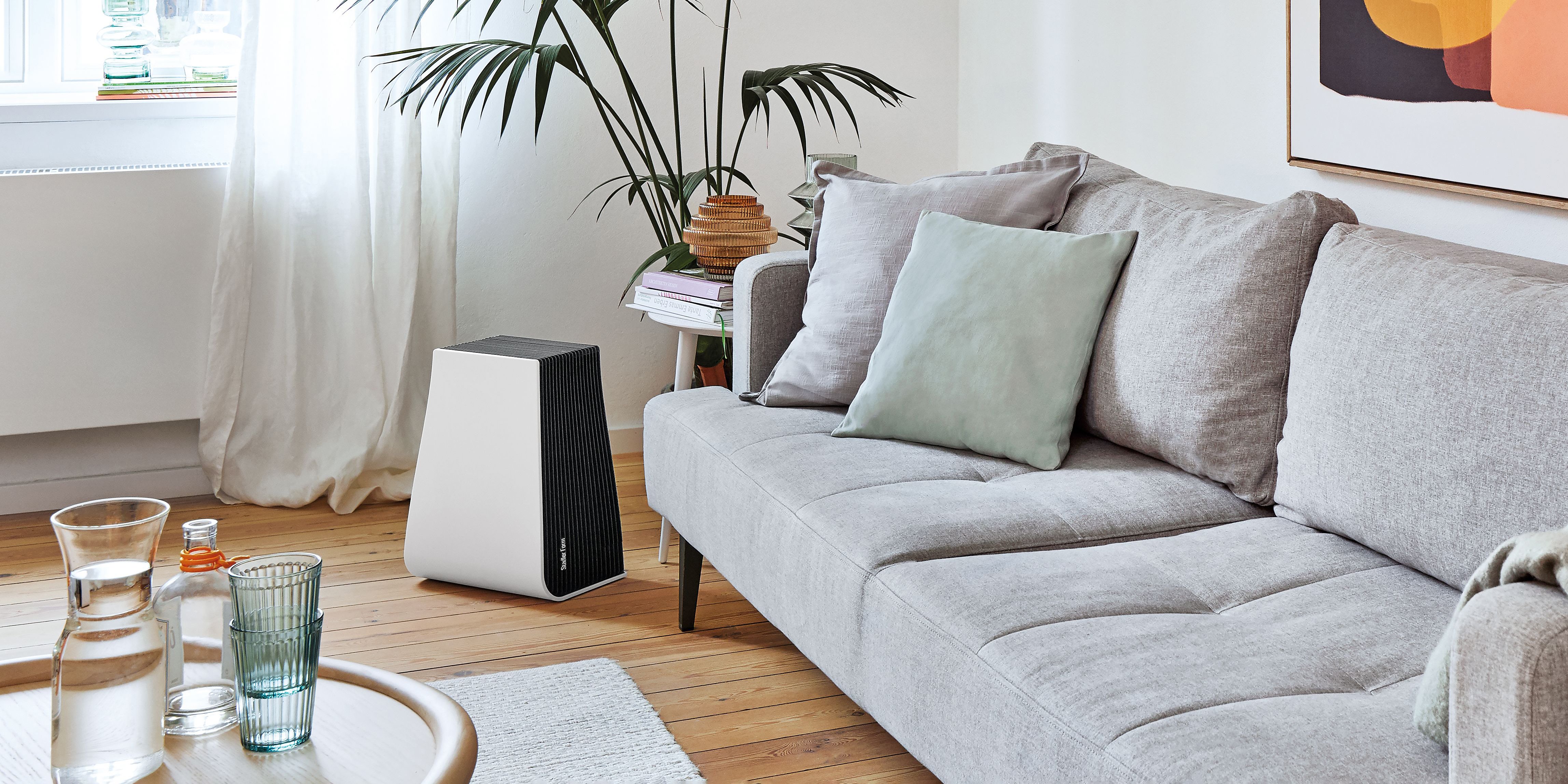 George air washer by Stadler Form in a living room next to a grey sofa